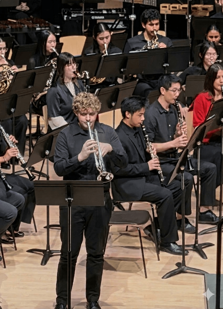 Trumpet soloist standing on stage beneath warm lights